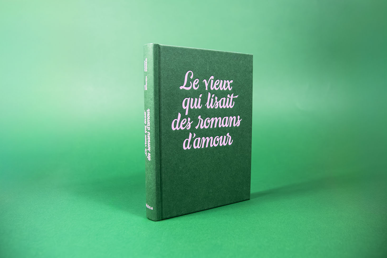 couverture sans rabat du vieux qui lisait des romans d'amour, lettrage sur mesure, ou lettering rose sur fond vert, sur du papier Fedrigoni